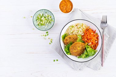 Orzo pasta, carrots and chicken burgers in white bowl. Risoni pasta. Lunch. Top view, above, copy space