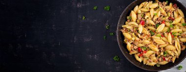 Conchiglie makarnası. Kıymalı İtalyan makarna kabuğu, kabak, domates ve tatlı biber. Üst görünüm, yukarıda