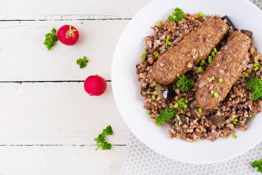 Sağlıklı bir akşam yemeği. Karabuğday lapalı yemek kasesi, fırında et ve kızarmış patlıcan. Üst görünüm, yukarıda