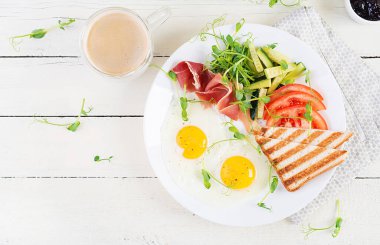 İngiliz kahvaltısı - sahanda yumurta, jamon, tost ve taze sebze salatası. Üst görünüm, genel görünüm