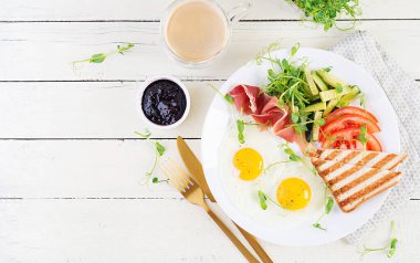 İngiliz kahvaltısı - sahanda yumurta, jamon, tost ve taze sebze salatası. Üst görünüm, genel görünüm