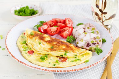 Kahvaltıda. Domatesli omlet, peynir ve etli terrine ya da beyaz tabakta köfte. Frittata - İtalyan omleti. Keto diyeti.