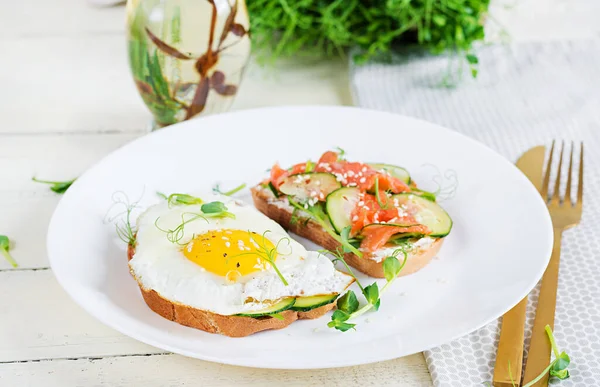 Diyet kahvaltı. Tuzlu somon salatalı sandviç, yeşil salatalık, salatalık, sahanda yumurta ve mikroyeşil.
