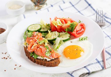 Diyet kahvaltı. Kızarmış yumurta ve sandviç, tuzlu somon ve salatalık, domates, marul..