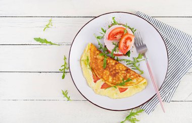 Kahvaltıda. Domatesli omlet, peynirli sandviç ve haşlanmış sosis. Frittata - İtalyan omleti. Üst görünüm, genel görünüm