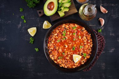 Koyu arkaplanda Chili Con Carne. Meksika mutfağı. Üst görünüm, yukarıda