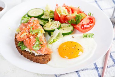Diyet kahvaltı. Kızarmış yumurta ve sandviç, tuzlu somon ve salatalık, domates, marul..