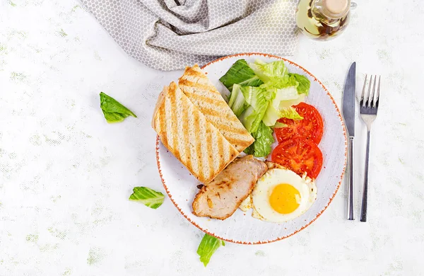 Domuz dilimli yumurta, domates ve tost. Lezzetli İngiliz Kahvaltısı. Brunch olsun. Üst görünüm, genel görünüm
