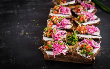 Çavdar ekmeği, ançüez, soğan ve domates soslu sandviç..