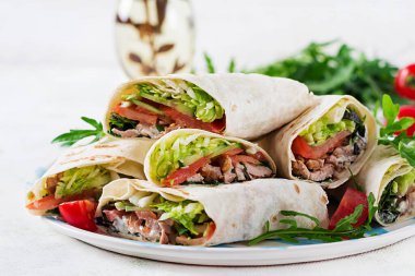 Hafif arka planda sığır etli ve sebzeli dürüm. Sığır eti, Meksika yemeği..