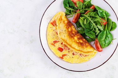 Domatesli omlet ve beyaz tabakta salata. Frittata - İtalyan omleti. Üst görünüm
