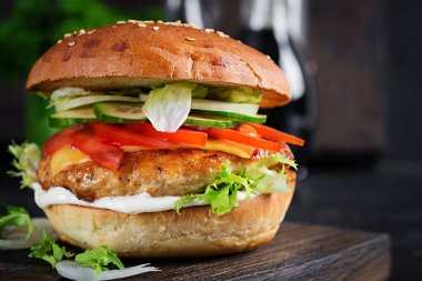 Hamburger, tavuk burger, peynir, domates, salatalık ve marul. Lezzetli burger. Kapat.