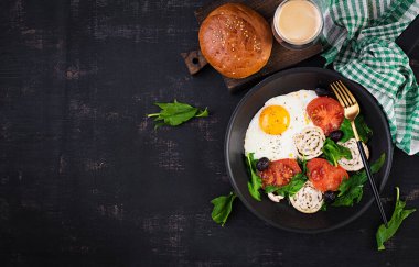 Kızarmış yumurta, köfte, siyah zeytin, domates ve ıspanak. Keto kahvaltısı. Ketogenik menü. Üst görünüm, yukarıda