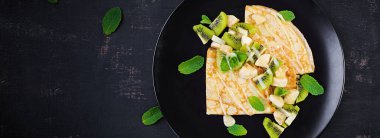 Krep, ince krep ya da siyah tabakta muz ve kivili blini. Krep haftası. Shrovetide. Üst görünüm, afiş