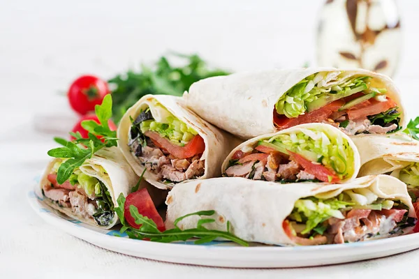 Burritos wraps with beef and vegetables on light  background. Beef tortilla, mexican food.
