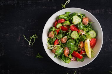Tuzlu somon balığı, limon, salatalık, zeytin, domates, yeşil marul salatası ve ballı hardal soslu ketojenik salata. Sağlıklı beslenme eğilimi. Üst görünüm