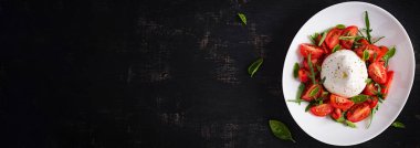 Domatesli salata ve fesleğen ve zeytinyağlı burrata peyniri. İtalyan yemeği. Üst görünüm, afiş