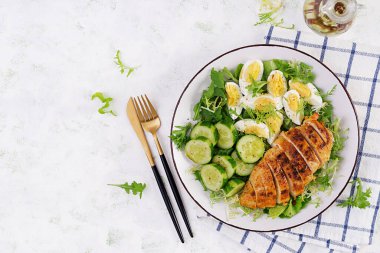 Izgara tavuk eti, haşlanmış yumurta ve salatalık salatası. Sağlıklı keto, ketojenik öğle yemeği. Kızarmış tavuk göğsü, fileto ve taze sebze salatası. Üst manzara, düz uzanma