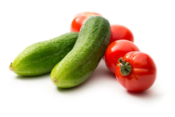 Čerstvé okurky a rajčata na bílém pozadí — Stock fotografie