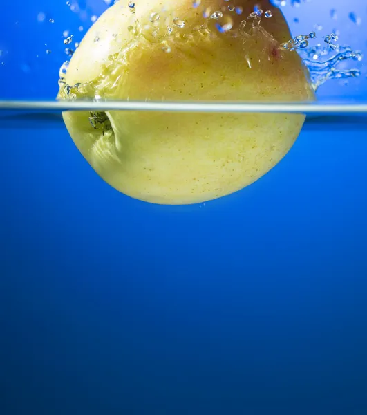 Mela gialla in spruzzata d'acqua — Foto Stock