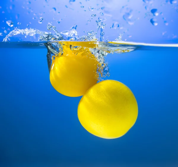 Yellow tomatoes in water splash — Stock Photo, Image