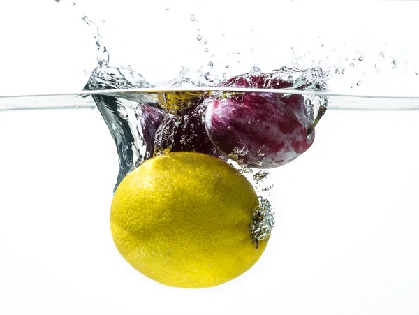 Fresh plums and lemon in water splash — Stock Photo, Image