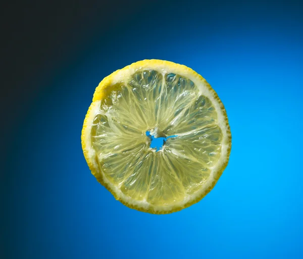 Slice of lemon on blue — Stock Photo, Image