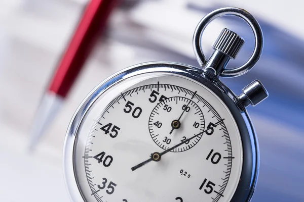 Stopwatch en pen op de achtergrond van papieren kaarten — Stockfoto