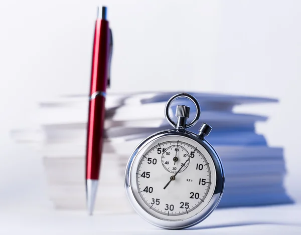 Stopwatch and pen on background of paper cards — Stock Photo, Image
