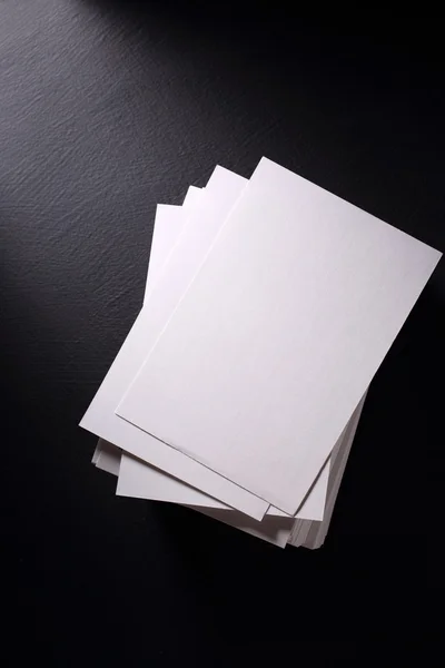 Пачка белых бумажных карточек на черном — стоковое фото