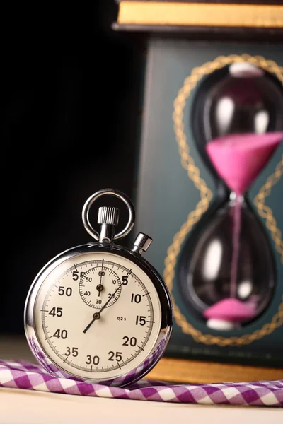 Siyah arka planda kronometre ve kum saati — Stok fotoğraf