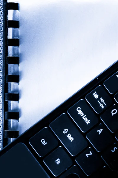 Notebook s klávesnicí počítače na něm — Stock fotografie