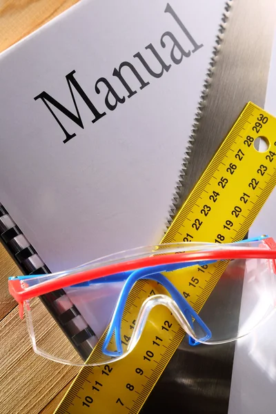 Règle, manuel, scie à main et lunettes — Photo