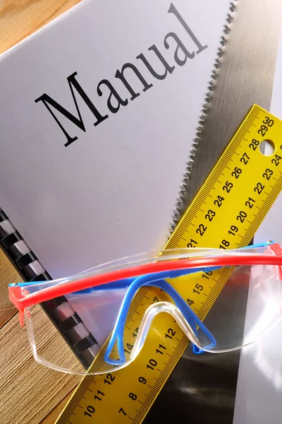 Ruler, manual, handsaw and goggles — Stock Photo, Image