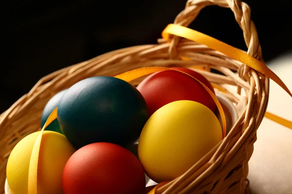 Easter eggs with yellow ribbon in basket — Stock Photo, Image