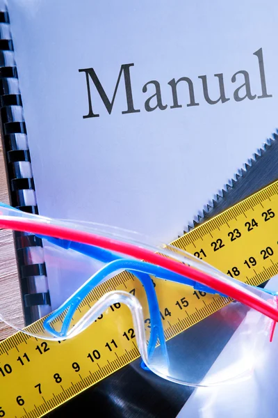 Ruler, manual, handsaw and goggles — Stock Photo, Image