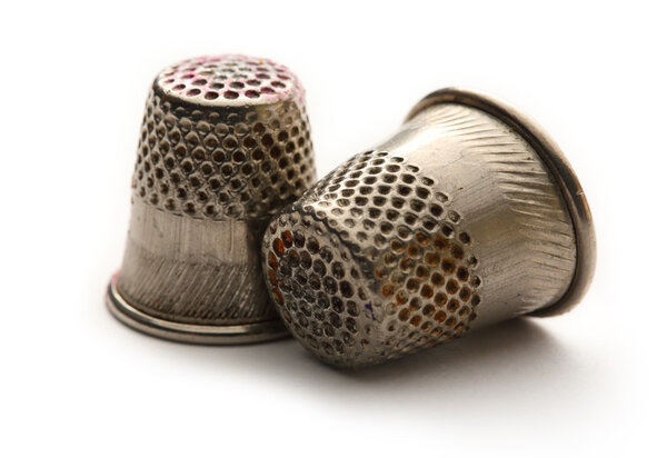 Two metal sewing thimbles on white