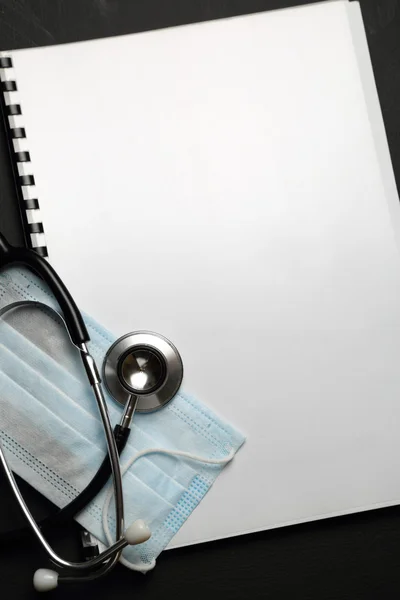 Stetoskop, maska i puste notebook — Zdjęcie stockowe