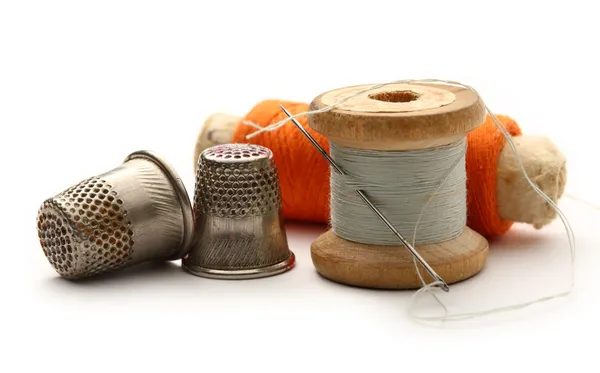 Sewing thimbles, bobbins and needle — Stock Photo, Image