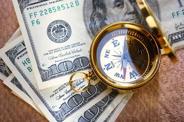 Золотой винтажный компас и деньги — стоковое фото