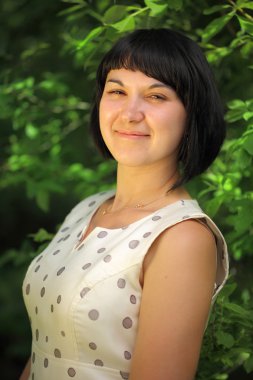 Yeşil ağaç arka plan üzerinde duran genç kadın