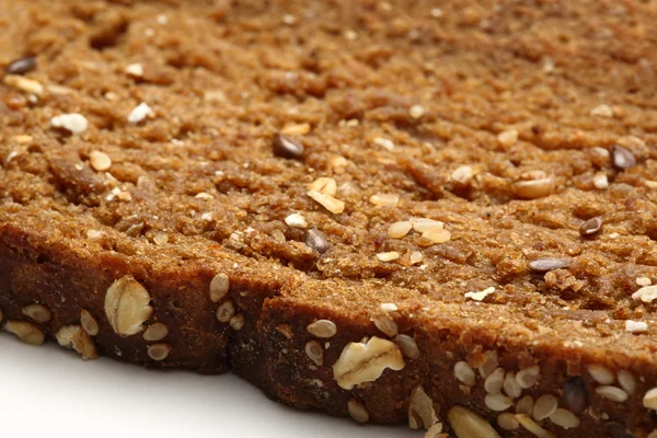 Slice of brown bread on white — Stock Photo, Image