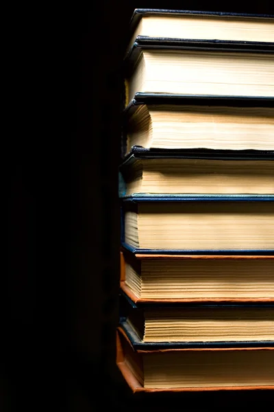 Stack of books isolated on the black background — Stok fotoğraf