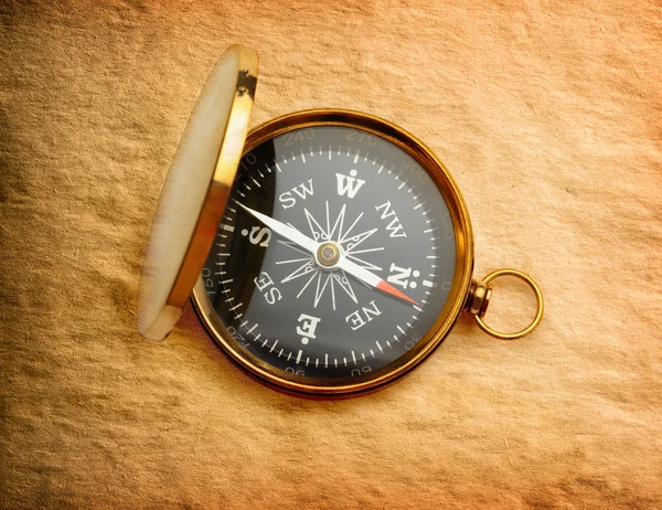 Single golden compass on paper background — Stock Photo, Image