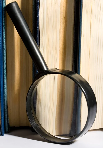 Stapel boeken en vergrootglas — Stockfoto