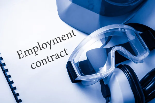 Arbeidsovereenkomst met bril, oortelefoons en helm — Stockfoto