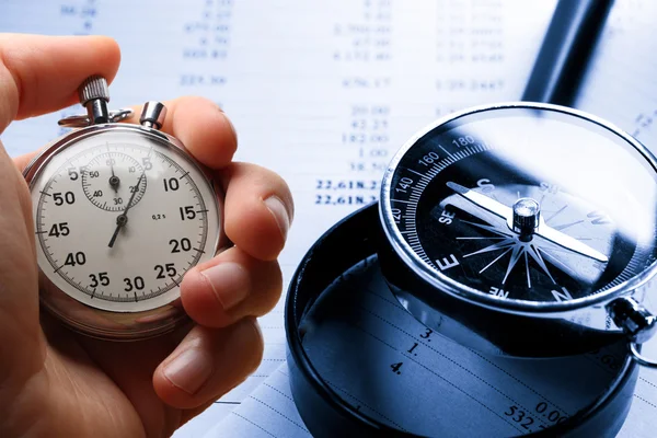 Hand holding stopwatch on budget numbers — Stock Photo, Image