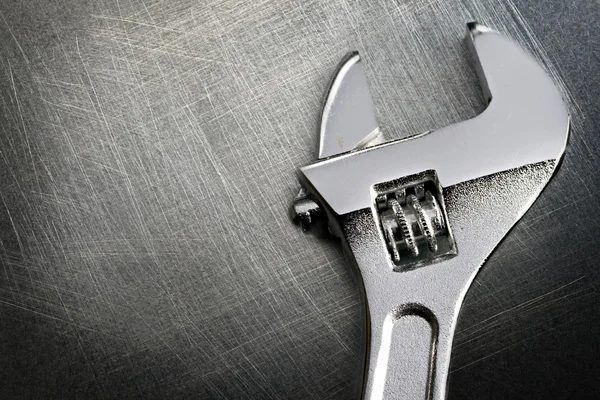 Schraubenschlüssel auf kratzigem Hintergrund aus Stahl — Stockfoto