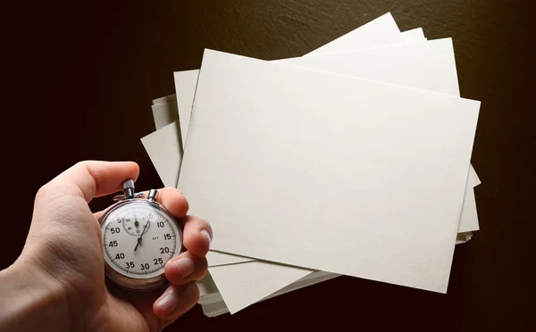 Cartes en papier sur noir et main avec chronomètre — Photo