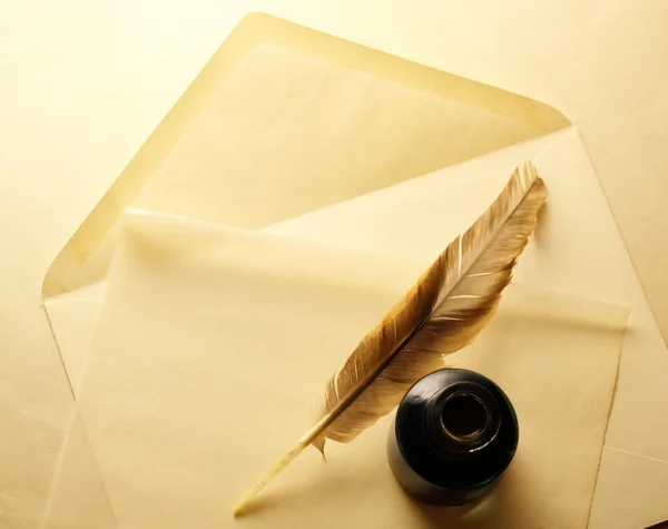 Envelope with inkwell and feather — Stock Photo, Image